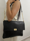 Clutch Noir negro con cadena dorada en modelo