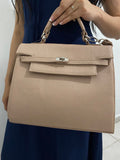 Bolsa Kelly Taupe con modelo vista frontal sosteniendo