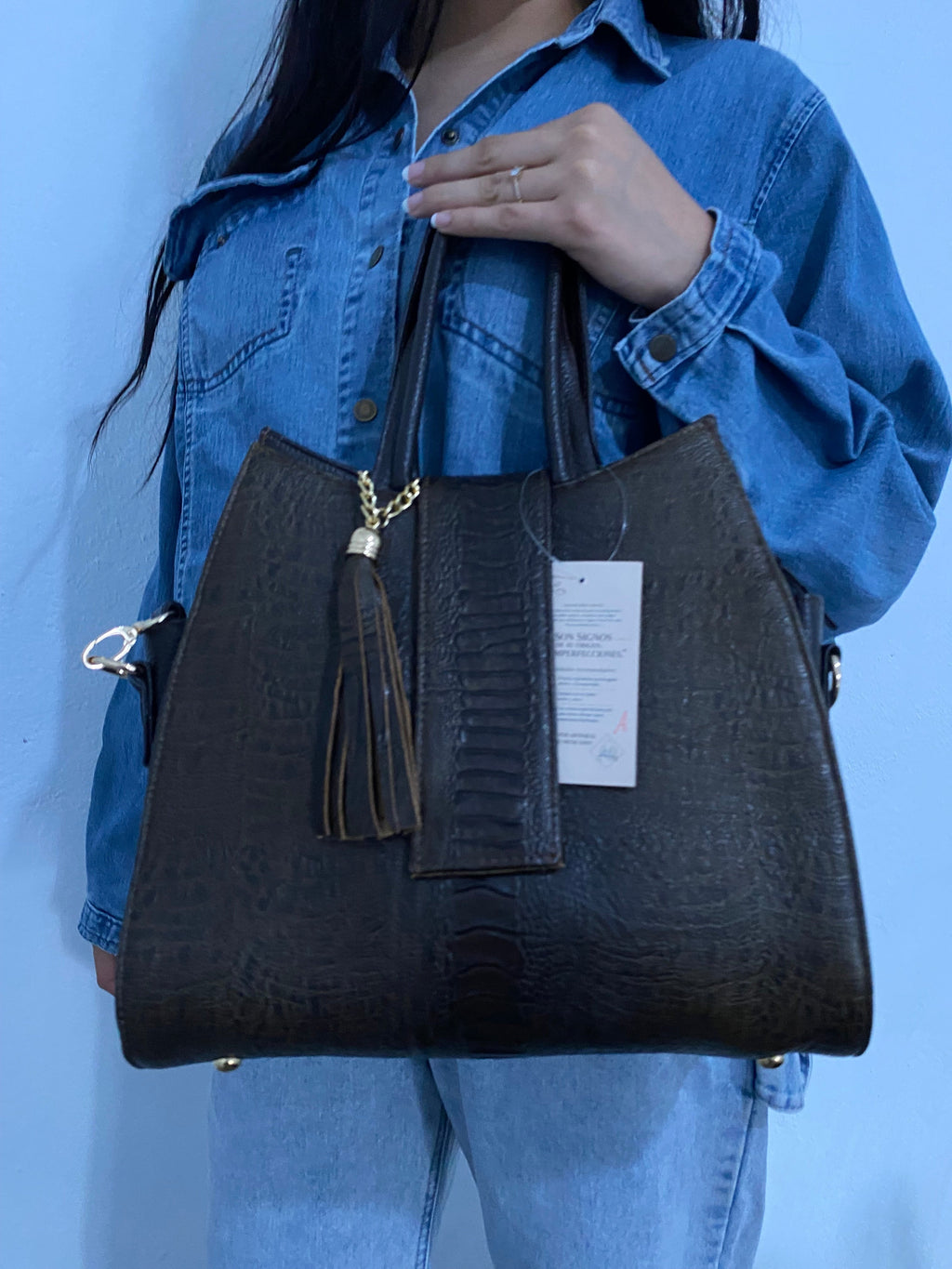 Tote Mixta Café Oscuro sostenida vista lateral detalle pies metálicos y bolsillo trasero