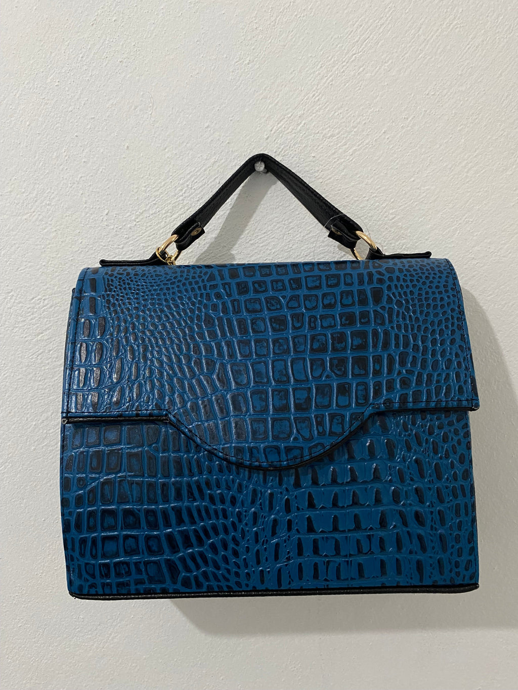 Satchel Croc Azul Cobalto colgada vista frontal como tote con asas largas y borla plateada