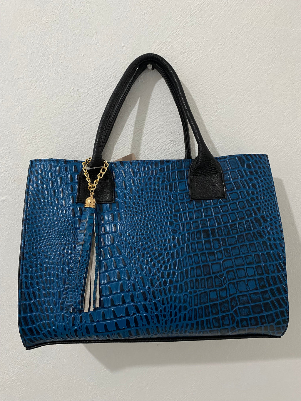 Satchel Croc Azul Cobalto vista lateral negra textura pebble con borla