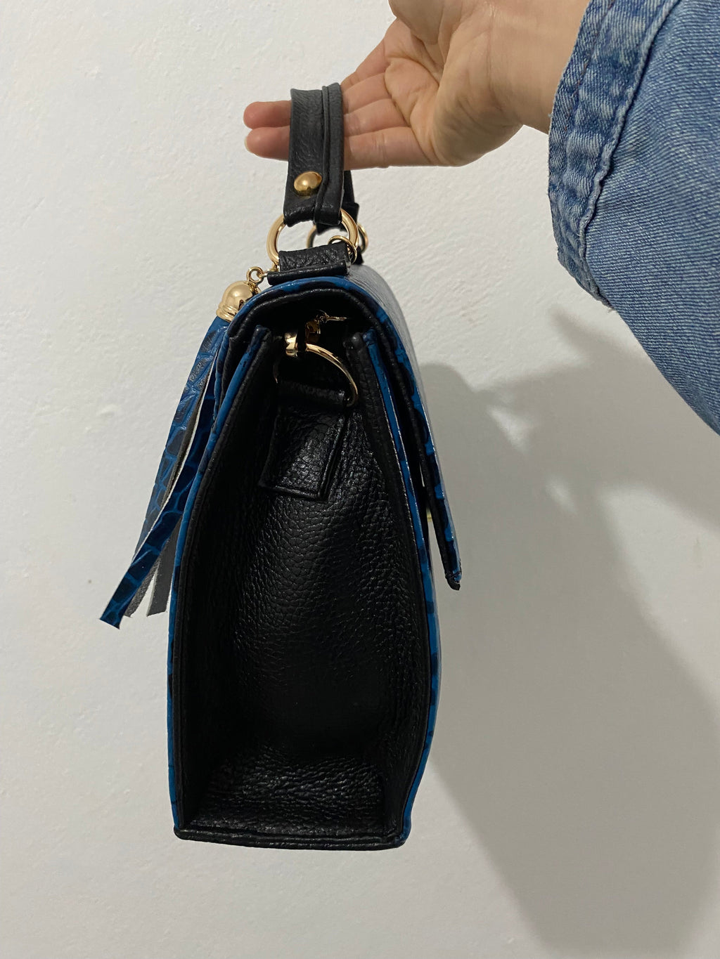 Satchel Croc Azul Cobalto sostenida vista lateral completa con etiqueta piel genuina