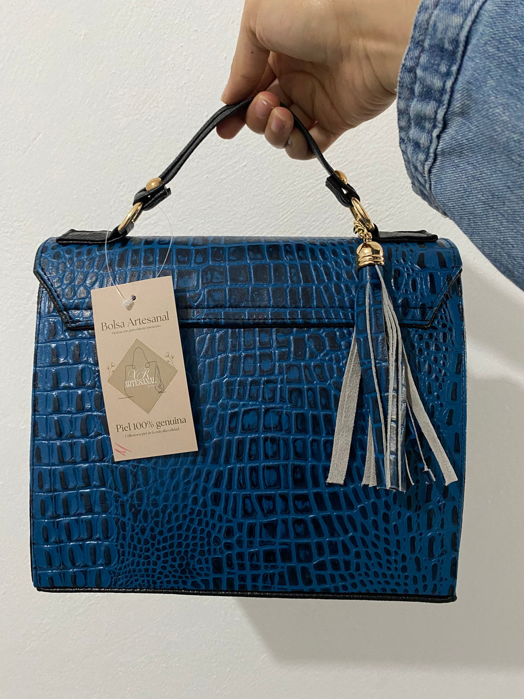 Satchel Croc Azul Cobalto sostenida vista trasera con bolsillo cremallera y etiqueta