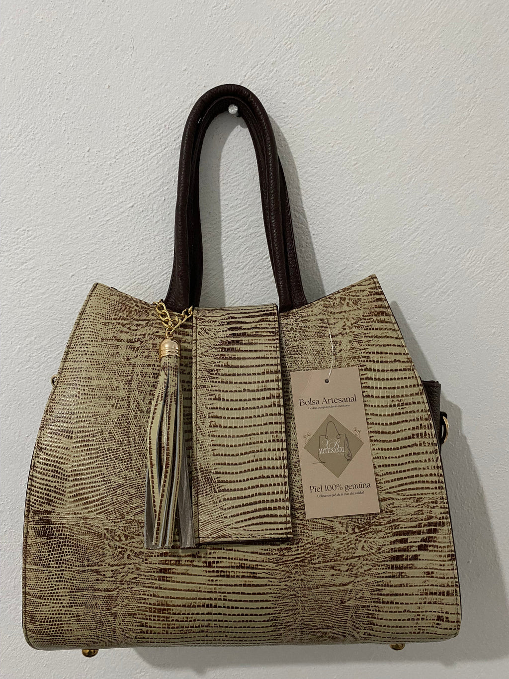 Bolsa Tote Lagarto Dorado colgada con etiqueta piel genuina