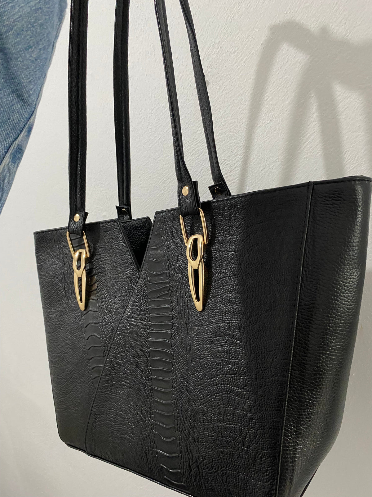 Tote V-Cut Negra Textura Mixta colgada vista lateral detalle textura mixta y herrajes dorados