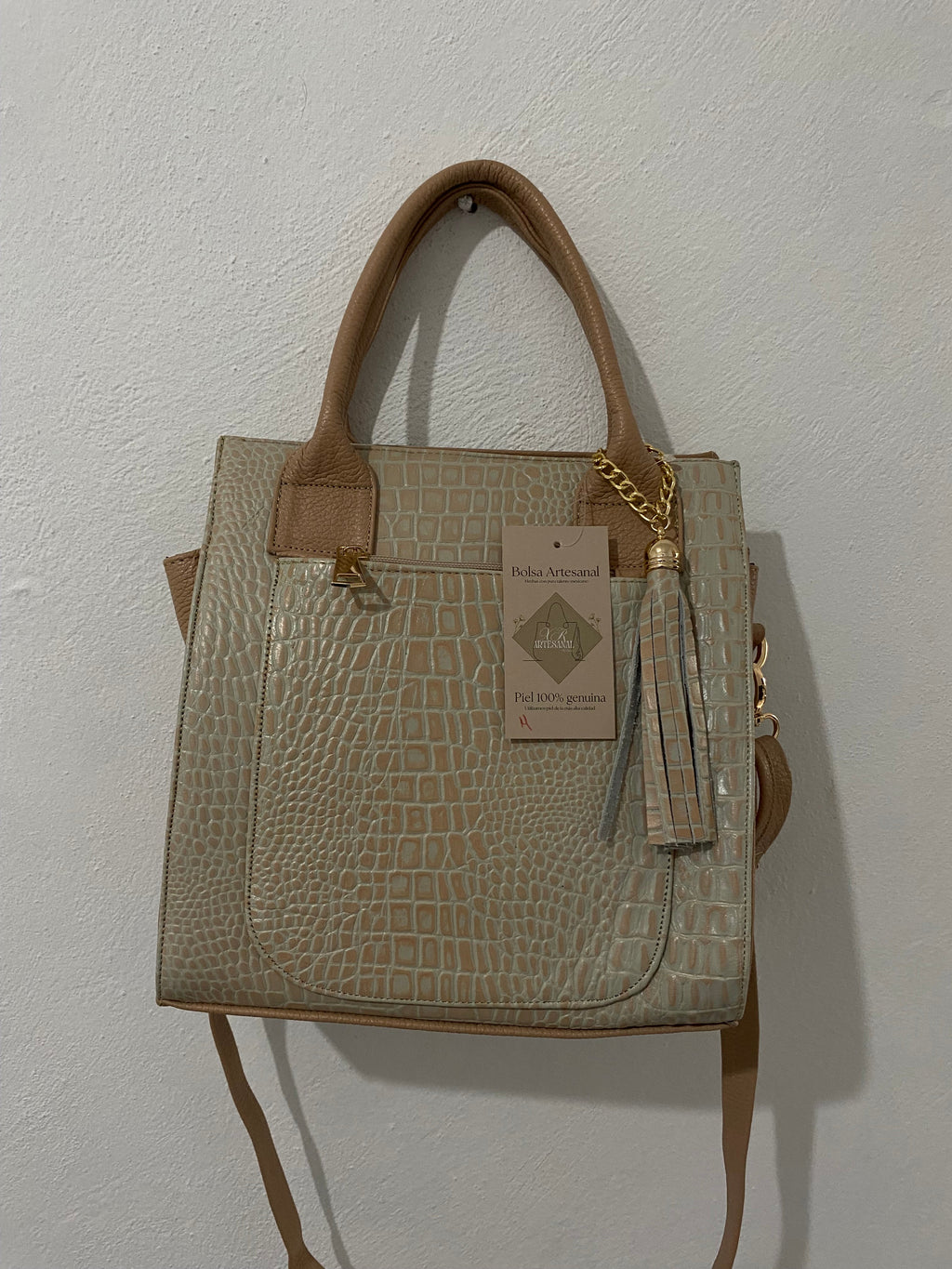 Bolsa Tote Arena colgada en pared con etiqueta artesanal