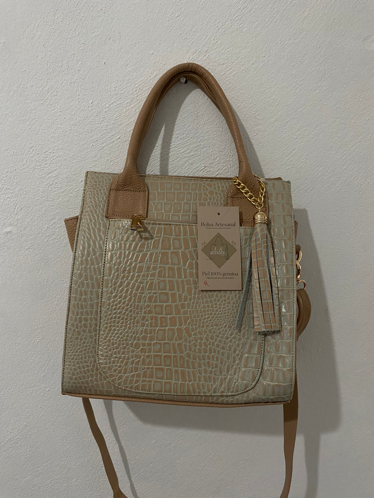 Bolsa Tote Arena colgada en pared con etiqueta artesanal