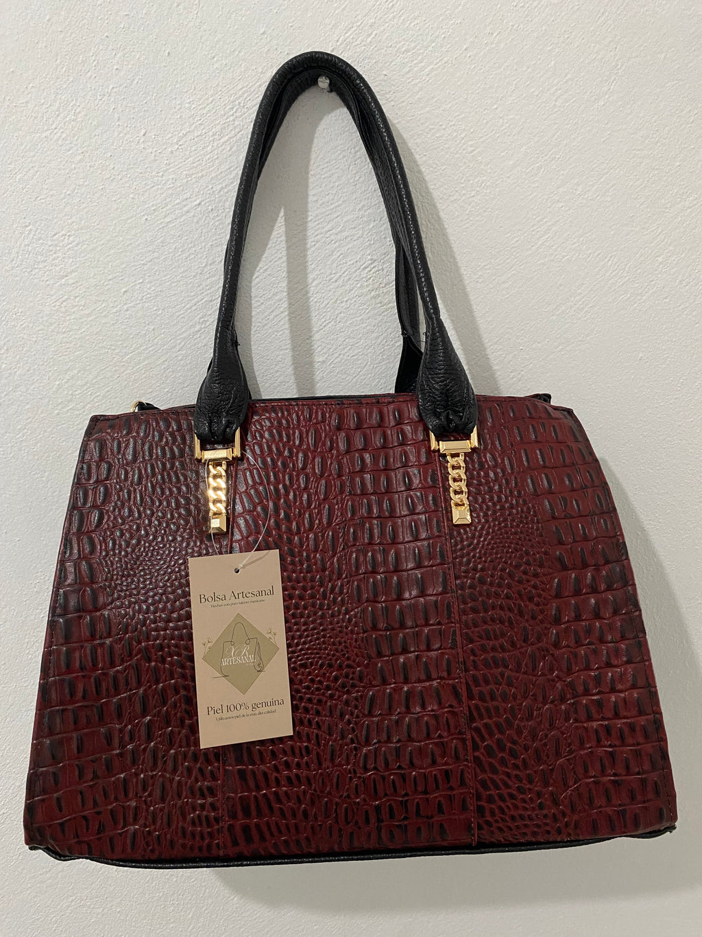 Bolsa Cocodrilo Vino colgada con etiqueta piel genuina