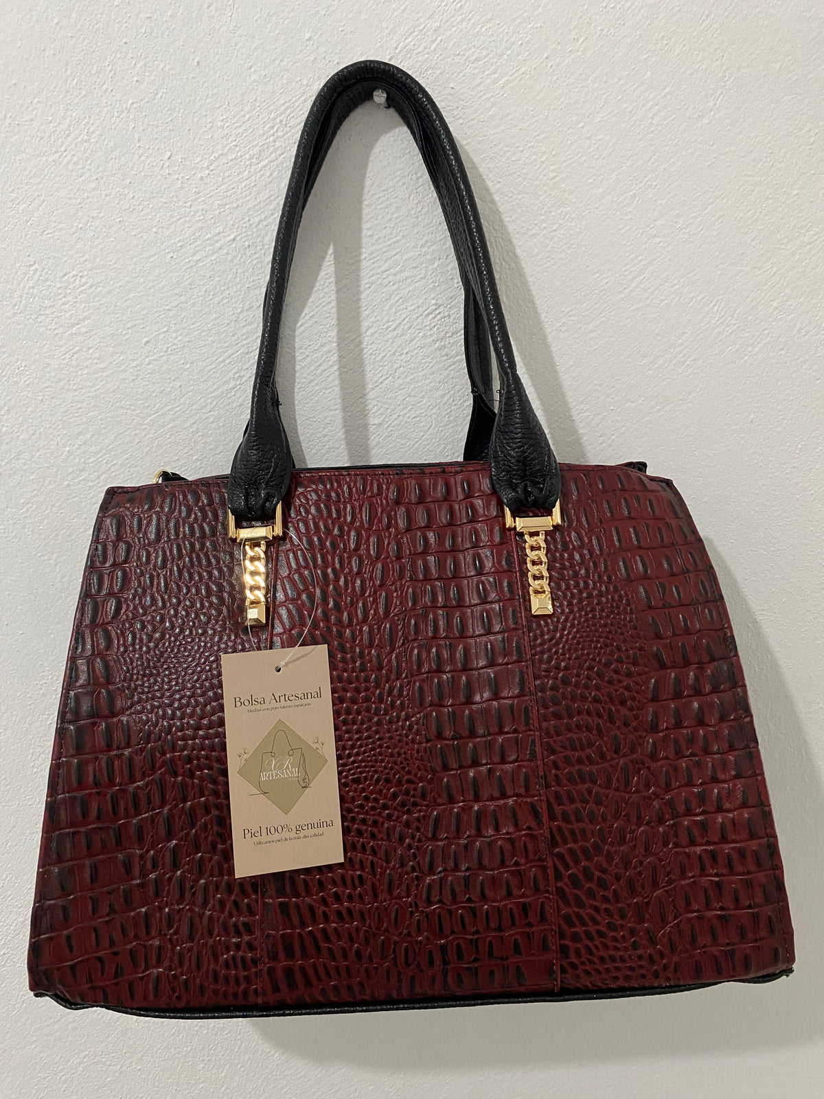 Bolsa Cocodrilo Vino colgada con etiqueta piel genuina