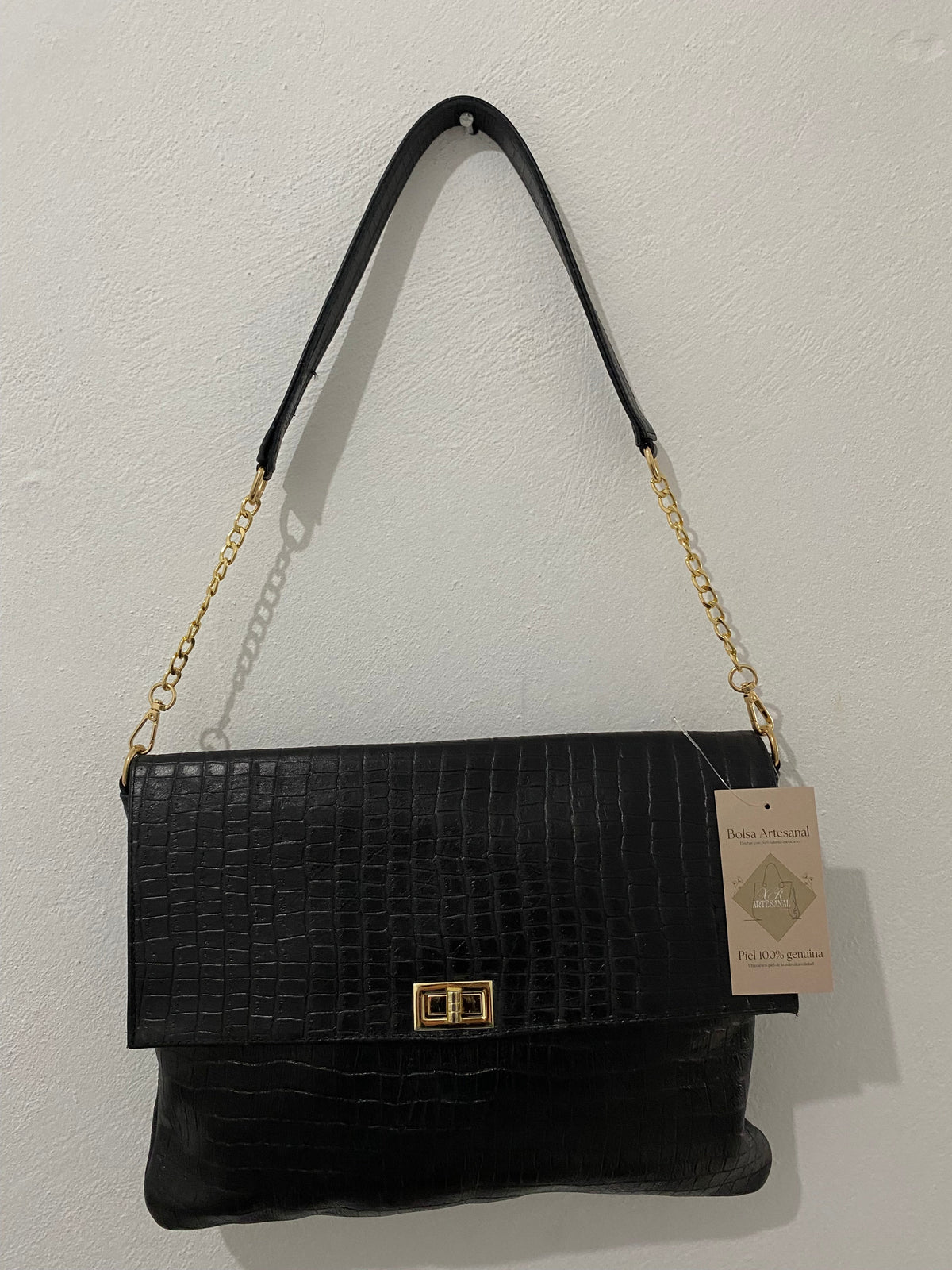 Clutch Noir negro colgado con etiqueta artesanal