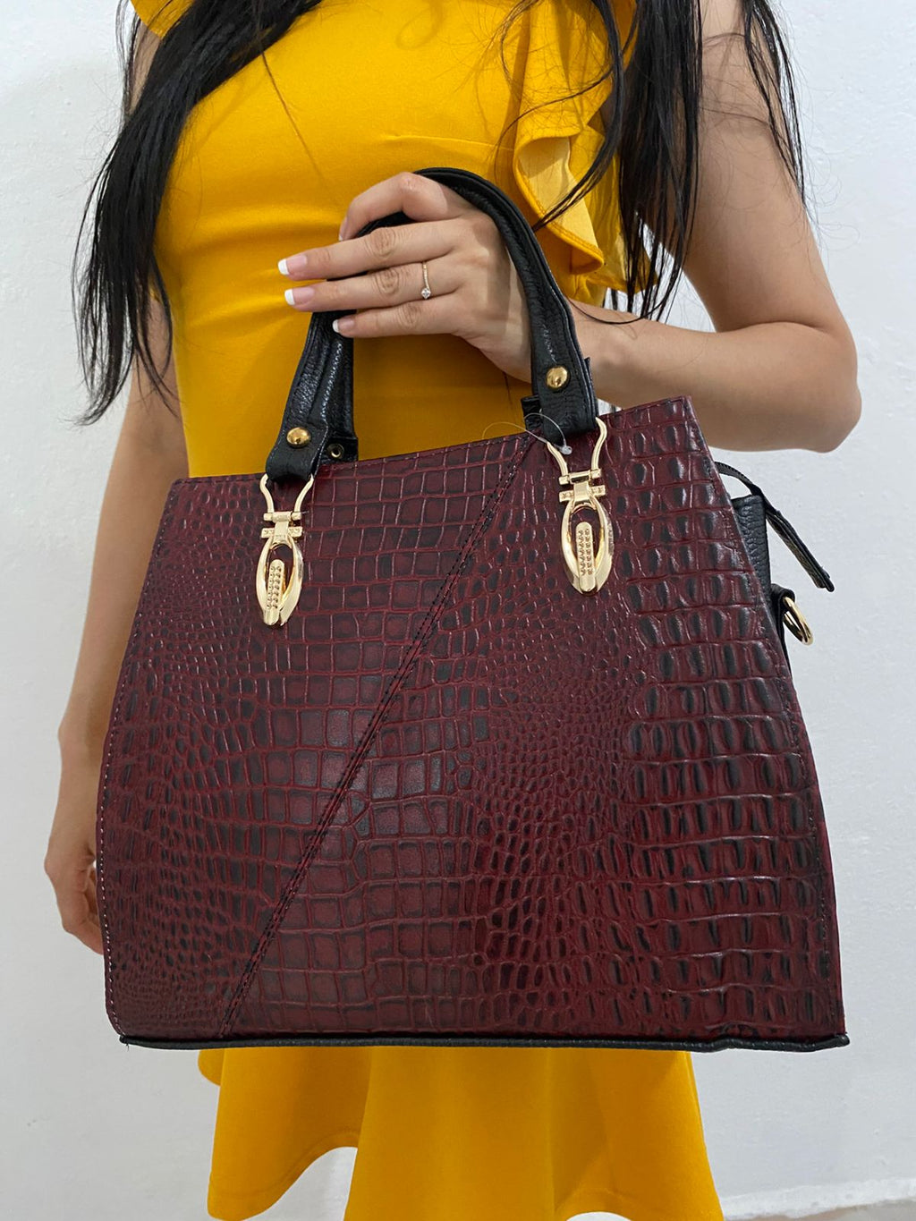 Handbag Croc Vino Herrajes Dorados con modelo vista frontal sosteniendo