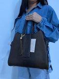 Tote Mixta Café Oscuro con modelo vista frontal sosteniendo detalle borla cadena dorada